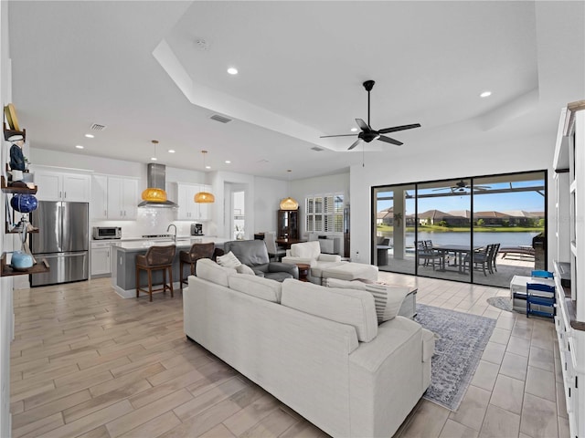 13056 Steinhatchee Loop, Venice, FL 34293 - living area with ceiling fan, recessed lighting, a raised ceiling, light wood finished floors, and a water view