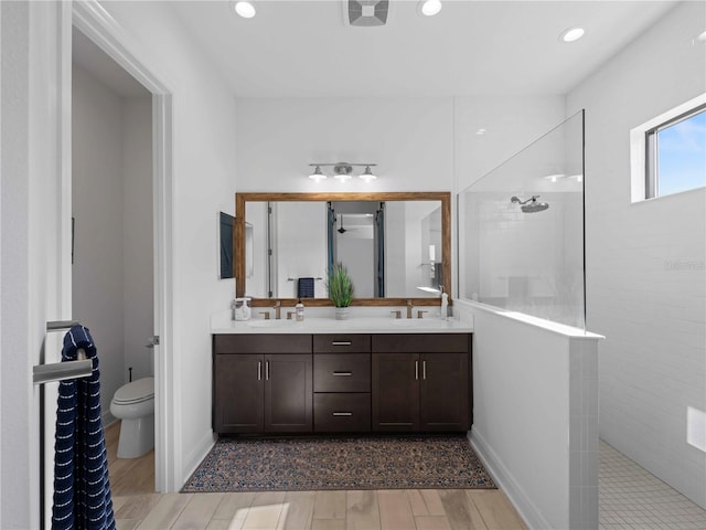 13056 Steinhatchee Loop, Venice, FL 34293 - bathroom featuring double vanity, walk in shower, toilet, wood finished floors, and recessed lighting