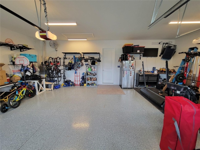 13056 Steinhatchee Loop, Venice, FL 34293 - garage featuring freestanding refrigerator, a garage door opener, and a workshop area