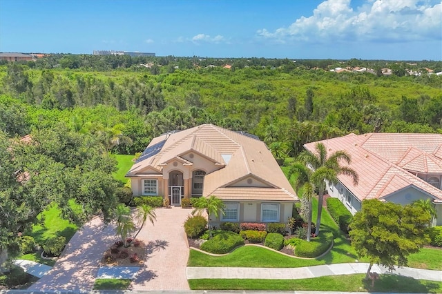 5018 Bella Terra Dr, Venice, FL 34293 - view of front facade with a wooded view, stucco siding, and driveway
