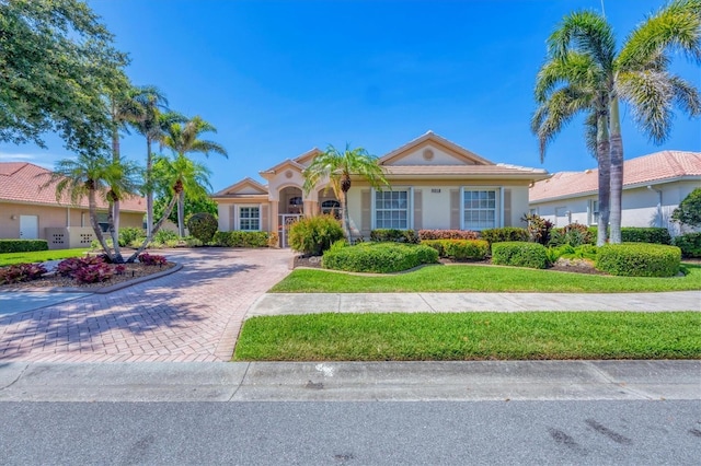 5018 Bella Terra Dr, Venice, FL 34293 - view of front facade featuring decorative driveway, stucco siding, and a front lawn
