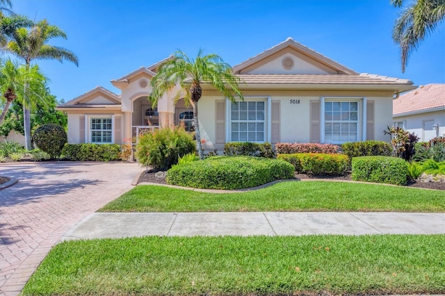 5018 Bella Terra Dr, Venice, FL 34293 - view of front of home featuring a front lawn, stucco siding, decorative driveway, and a tiled roof