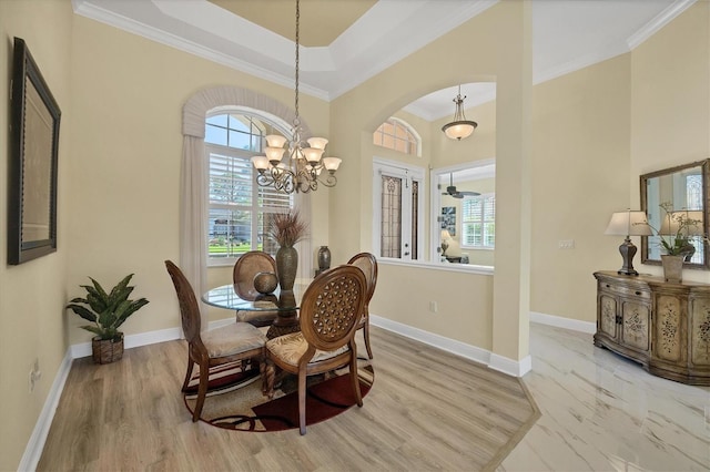 5018 Bella Terra Dr, Venice, FL 34293 - dining space with a chandelier, arched walkways, ornamental molding, and light wood finished floors