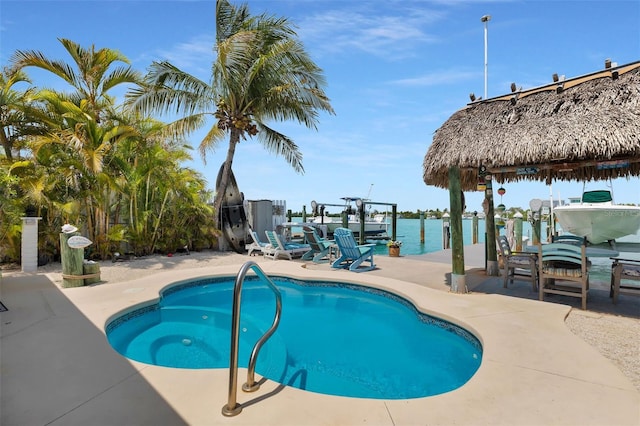 8 Sadowski Cswy, Key Colony Beach, FL 33051 - outdoor pool with boat lift, a dock, a water view, and a patio