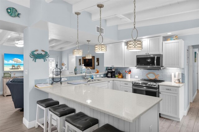 8 Sadowski Cswy, Key Colony Beach, FL 33051 - kitchen with appliances with stainless steel finishes, a sink, a peninsula, beamed ceiling, and backsplash