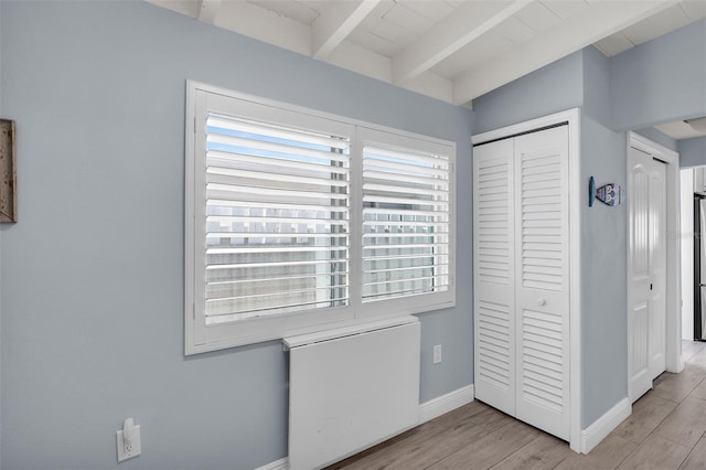 8 Sadowski Cswy, Key Colony Beach, FL 33051 - unfurnished bedroom featuring beam ceiling, baseboards, a closet, and light wood finished floors