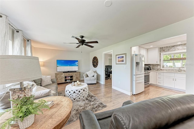 5207 5th Avenue Dr NW, Bradenton, FL 34209 - living room featuring light wood finished floors, ceiling fan, and baseboards