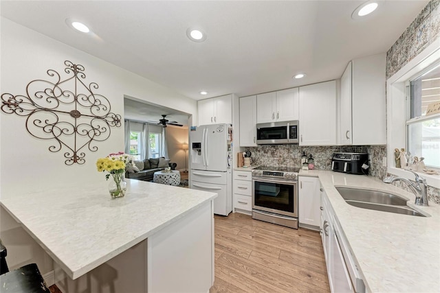 5207 5th Avenue Dr NW, Bradenton, FL 34209 - kitchen with appliances with stainless steel finishes, a sink, light countertops, white cabinetry, and recessed lighting