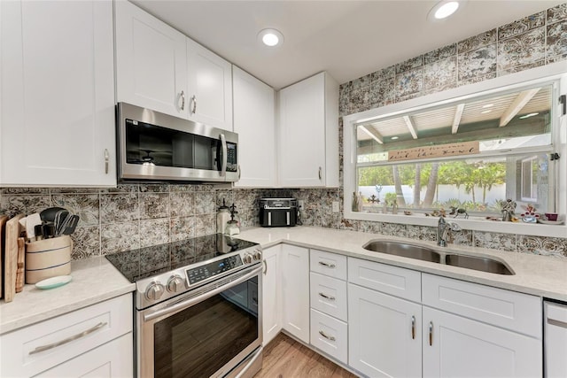 5207 5th Avenue Dr NW, Bradenton, FL 34209 - kitchen with stainless steel appliances, a sink, white cabinetry, tasteful backsplash, and recessed lighting