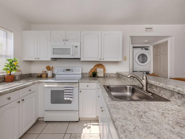 25050 Sandhill Blvd Unit 6A3, Punta Gorda, FL 33983 - kitchen featuring white appliances, stacked washing machine and dryer, a sink, and white cabinetry
