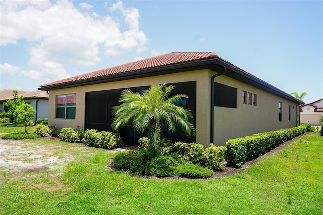 136 Positano Trl, Nokomis, FL 34275 - view of home's exterior with a tile roof, stucco siding, and a lawn