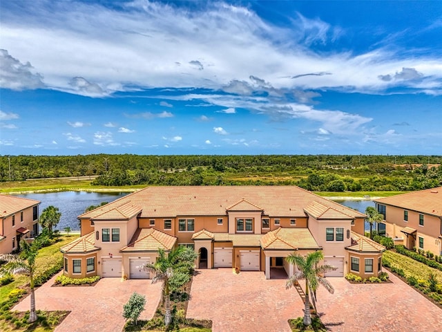 10213 Staggerbush Dr Unit 202, Venice, FL 34293 - view of front of property with decorative driveway, a water view, stucco siding, and a tiled roof