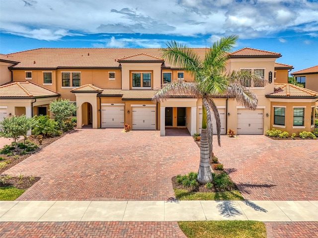 10213 Staggerbush Dr Unit 202, Venice, FL 34293 - view of front of house featuring stucco siding, driveway, a garage, and a tiled roof