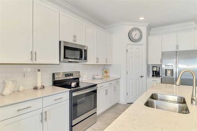 10213 Staggerbush Dr Unit 202, Venice, FL 34293 - kitchen featuring stainless steel appliances, a sink, crown molding, white cabinetry, and light stone counters