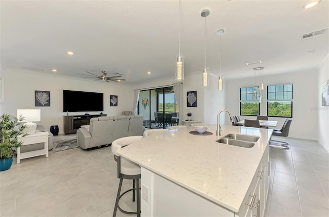 10213 Staggerbush Dr Unit 202, Venice, FL 34293 - kitchen featuring a sink, light tile patterned floors, white cabinets, a center island with sink, and recessed lighting