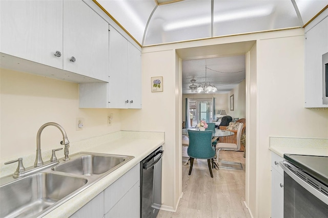 708 Tamiami Trl S Unit 115, Venice, FL 34285 - kitchen with black appliances, light wood-style floors, light countertops, white cabinets, and a chandelier