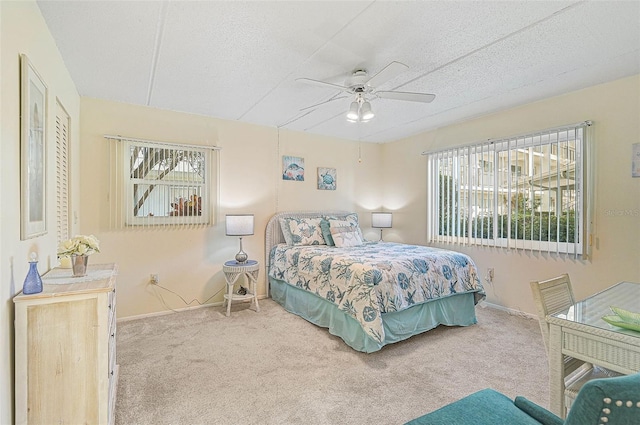 708 Tamiami Trl S Unit 115, Venice, FL 34285 - bedroom featuring multiple windows, carpet floors, a textured ceiling, and ceiling fan