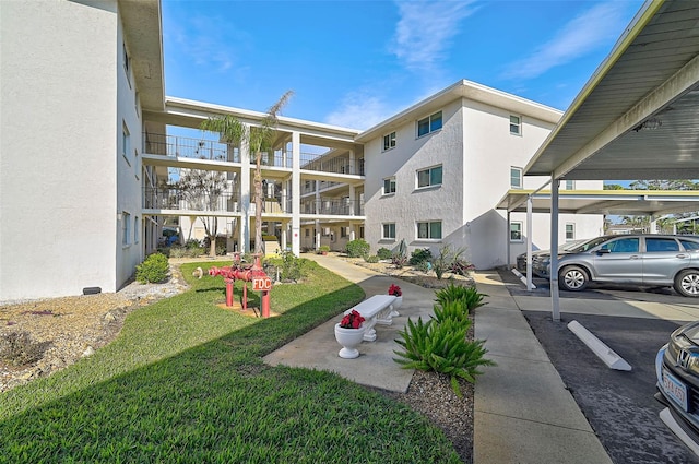 708 Tamiami Trl S Unit 115, Venice, FL 34285 - view of community with a lawn and covered parking