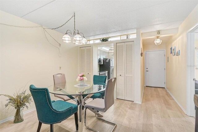 708 Tamiami Trl S Unit 115, Venice, FL 34285 - dining space with light wood finished floors and a chandelier