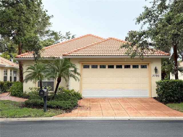 3790 Cadbury Cir Unit 40, Venice, FL 34293 - mediterranean / spanish-style home with stucco siding, a tile roof, an attached garage, and driveway