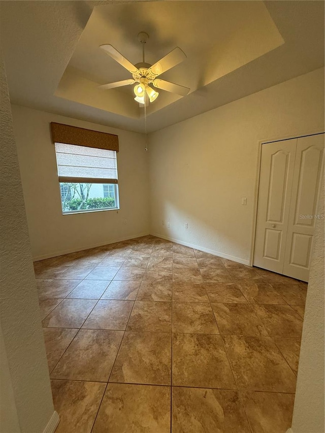 3790 Cadbury Cir Unit 40, Venice, FL 34293 - tiled empty room featuring a raised ceiling, ceiling fan, and baseboards