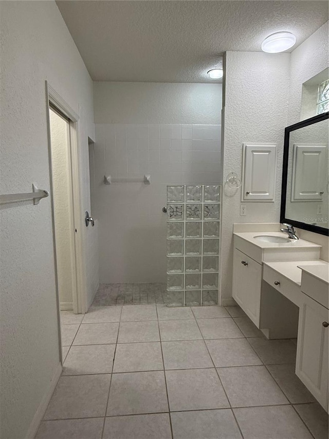 3790 Cadbury Cir Unit 40, Venice, FL 34293 - bathroom with vanity, a textured ceiling, tile patterned floors, a walk in shower, and a textured wall