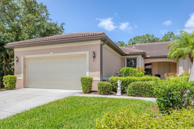 11103 Batello Dr, Venice, FL 34292 - mediterranean / spanish house featuring driveway, a tiled roof, a garage, and stucco siding