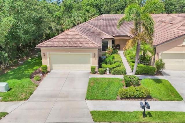 11103 Batello Dr, Venice, FL 34292 - mediterranean / spanish home featuring a tiled roof, driveway, stucco siding, an attached garage, and a front lawn