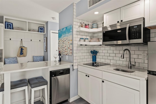 1555 Tarpon Center Dr Unit G 235, Venice, FL 34285 - kitchen featuring appliances with stainless steel finishes, open shelves, tasteful backsplash, light countertops, and white cabinets