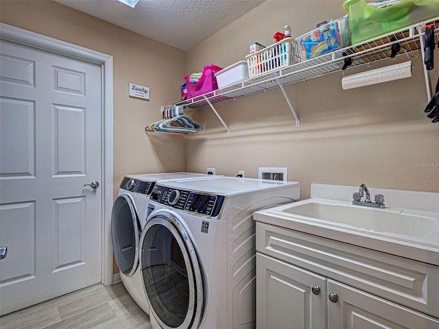 516 Tamiami Trl S Unit 303, Nokomis, FL 34275 - laundry area with washing machine and clothes dryer, light wood-type flooring, cabinet space, and a textured ceiling