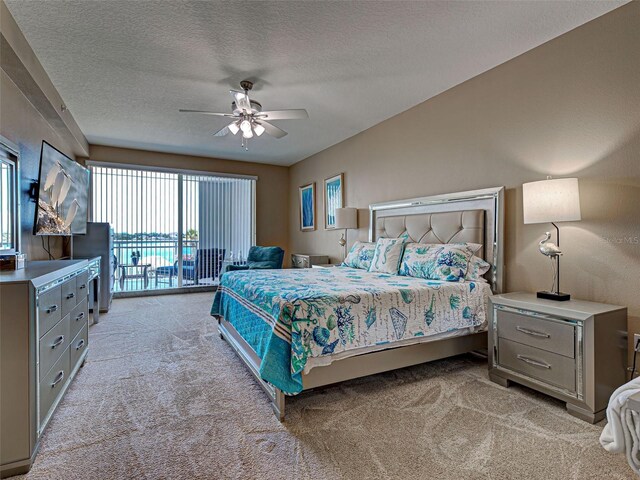 516 Tamiami Trl S Unit 303, Nokomis, FL 34275 - bedroom with light carpet, access to exterior, a textured ceiling, and ceiling fan