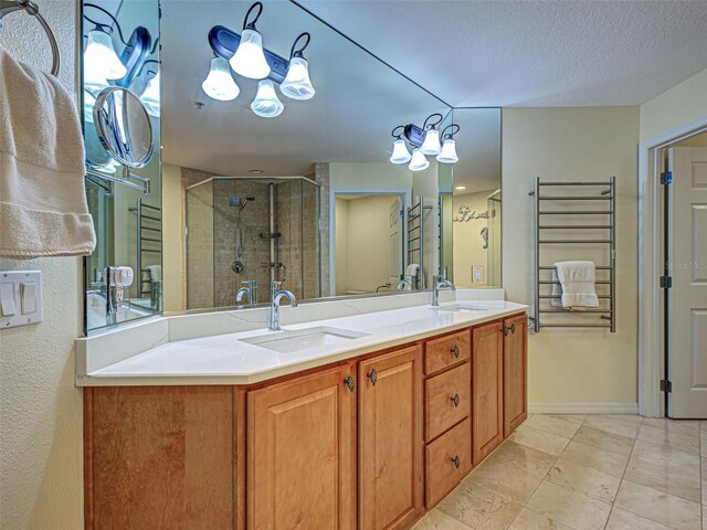 516 Tamiami Trl S Unit 303, Nokomis, FL 34275 - bathroom featuring a stall shower, double vanity, and a textured ceiling