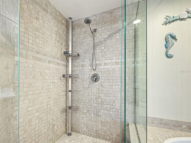 516 Tamiami Trl S Unit 303, Nokomis, FL 34275 - full bath featuring a stall shower, a textured ceiling, and a bath