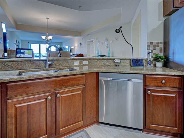 516 Tamiami Trl S Unit 303, Nokomis, FL 34275 - kitchen featuring dishwasher, backsplash, a chandelier, light stone countertops, and brown cabinets