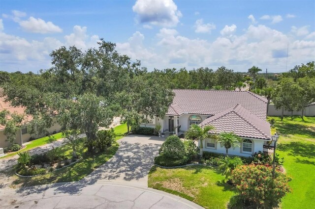 188 Grand Oak Cir, Venice, FL 34292 - view of front of home with a tile roof, stucco siding, curved driveway, and a front lawn