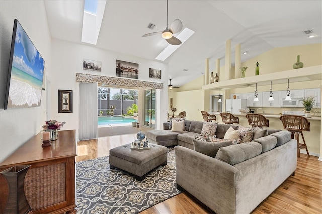 188 Grand Oak Cir, Venice, FL 34292 - living room featuring high vaulted ceiling, ceiling fan, wood finished floors, and a skylight