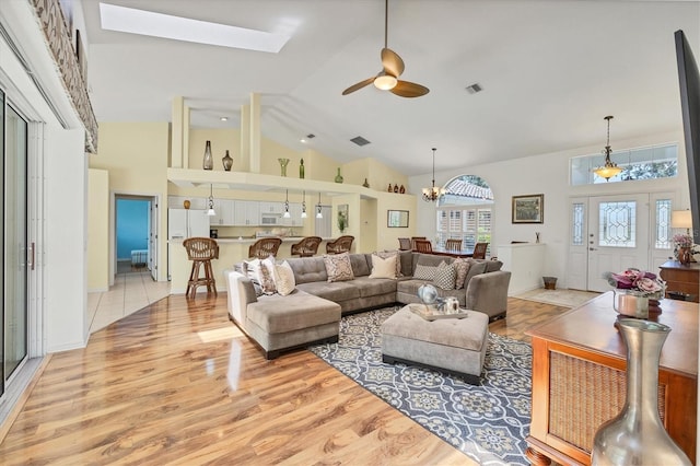 188 Grand Oak Cir, Venice, FL 34292 - living area featuring high vaulted ceiling, ceiling fan, wood finished floors, a chandelier, and a skylight
