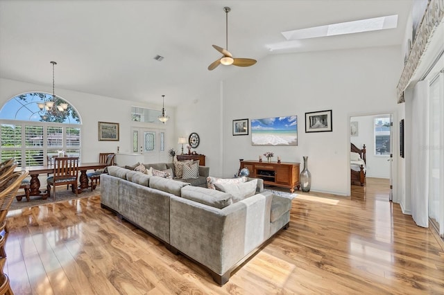 188 Grand Oak Cir, Venice, FL 34292 - living area featuring high vaulted ceiling, light wood-style floors, ceiling fan, a chandelier, and a skylight