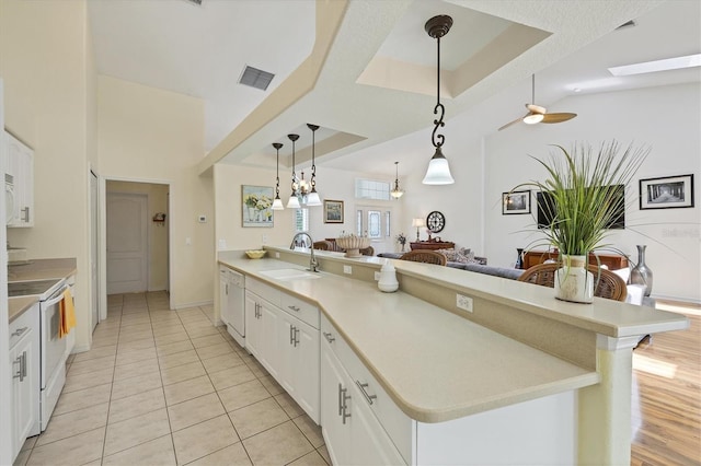 188 Grand Oak Cir, Venice, FL 34292 - kitchen with white appliances, white cabinets, open floor plan, a peninsula, and hanging light fixtures