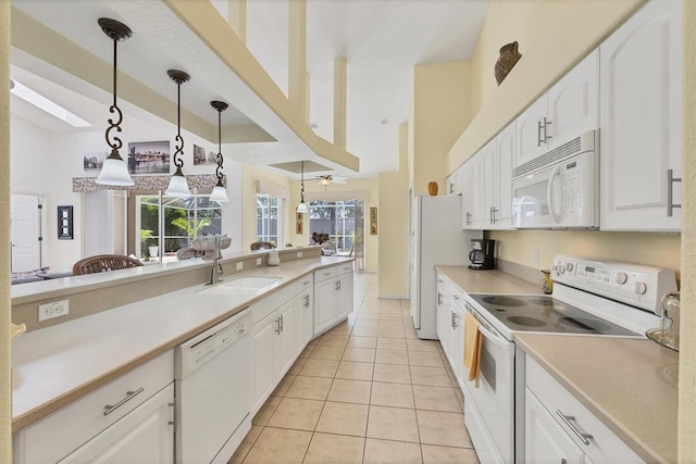 188 Grand Oak Cir, Venice, FL 34292 - kitchen with white appliances, light tile patterned floors, white cabinetry, pendant lighting, and a towering ceiling