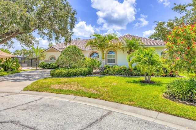 188 Grand Oak Cir, Venice, FL 34292 - mediterranean / spanish-style home featuring stucco siding, a front lawn, a tile roof, and concrete driveway