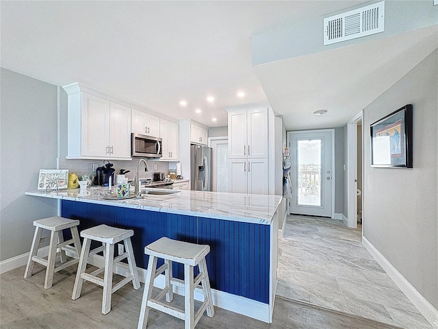 1100 Tarpon Center Dr Unit 503-5C, Venice, FL 34285 - kitchen with stainless steel appliances, a peninsula, baseboards, a kitchen breakfast bar, and recessed lighting