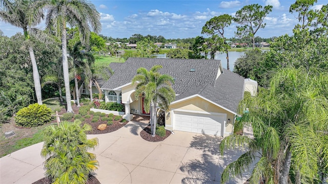 249 Hallcrest Ter, Port Charlotte, FL 33954 - view of front of home featuring stucco siding, driveway, a garage, roof with shingles, and a water view