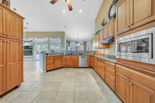 249 Hallcrest Ter, Port Charlotte, FL 33954 - kitchen featuring appliances with stainless steel finishes, a ceiling fan, under cabinet range hood, a peninsula, and backsplash