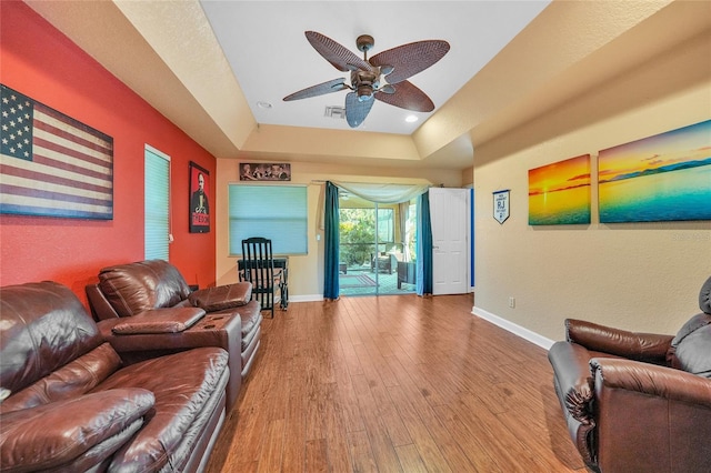 249 Hallcrest Ter, Port Charlotte, FL 33954 - living room featuring a ceiling fan, baseboards, wood finished floors, and a tray ceiling