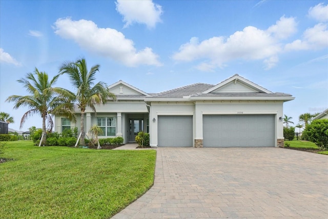 15336 Spanish Point Dr, Port Charlotte, FL 33981 - view of front facade featuring a garage, a front lawn, decorative driveway, stucco siding, and stone siding