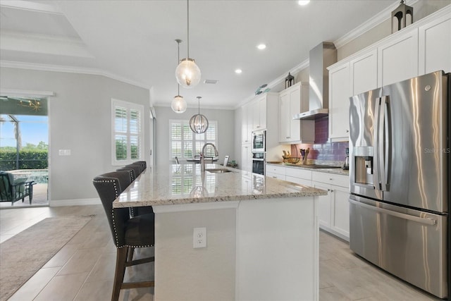 15336 Spanish Point Dr, Port Charlotte, FL 33981 - kitchen with stainless steel appliances, wall chimney exhaust hood, ornamental molding, white cabinets, and an island with sink