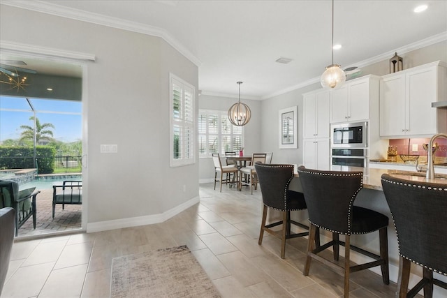 15336 Spanish Point Dr, Port Charlotte, FL 33981 - kitchen with appliances with stainless steel finishes, light stone countertops, white cabinets, decorative light fixtures, and ornamental molding