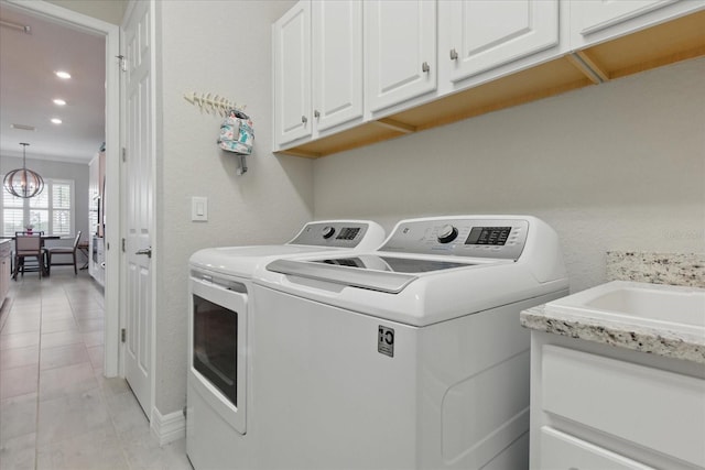 15336 Spanish Point Dr, Port Charlotte, FL 33981 - laundry room with separate washer and dryer, cabinet space, light tile patterned floors, recessed lighting, and a chandelier