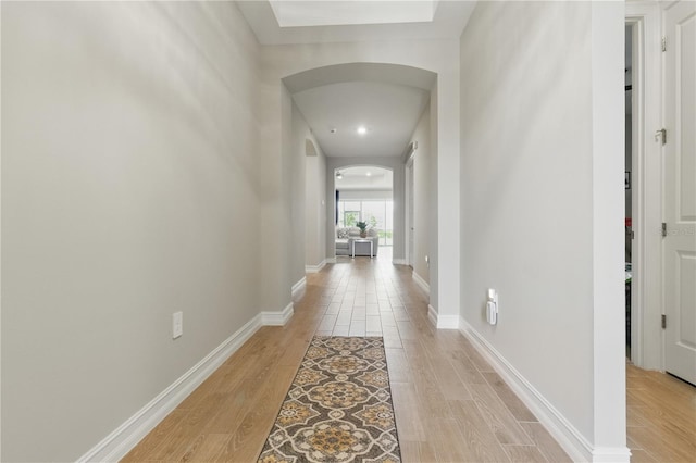 15963 Crofton Springs Way, Port Charlotte, FL 33953 - corridor featuring arched walkways, light wood-type flooring, and baseboards